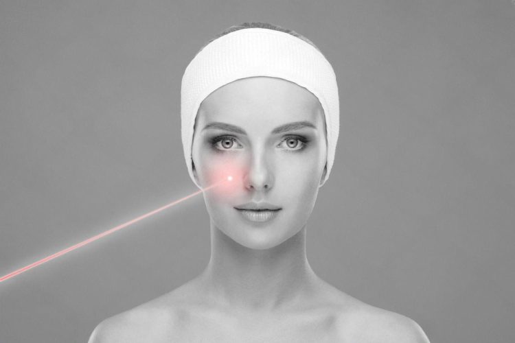 Close-up of a woman receiving a laser facial treatment on the cheek area
